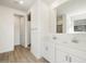 Bathroom featuring double sink vanity, modern hardware, wood-look tile flooring, and white walls at 16084 W Prickly Pear Trl, Surprise, AZ 85387