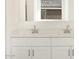 Close up of bathroom double sink vanity with modern hardware, white countertop, and white cabinets at 16084 W Prickly Pear Trl, Surprise, AZ 85387