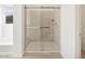 Modern bathroom featuring a glass enclosed shower and wood-look tile flooring and white walls at 16084 W Prickly Pear Trl, Surprise, AZ 85387