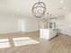 Open-concept kitchen and living area featuring stylish lighting and modern white cabinets at 16084 W Prickly Pear Trl, Surprise, AZ 85387