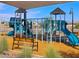 Community playground featuring blue slides, climbing structures, and a wood chip surface at 16084 W Prickly Pear Trl, Surprise, AZ 85387