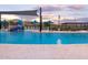 Community pool featuring a splash pad, shaded seating, and desert landscaping at 16084 W Prickly Pear Trl, Surprise, AZ 85387