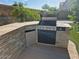 Outdoor kitchen with built-in grill, stone accents, and a beverage cooler, perfect for entertaining in the backyard at 2050 W Davis Rd, Phoenix, AZ 85023