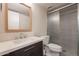 Bathroom with quartz countertop vanity, framed mirror, frosted glass shower door, and tile flooring at 7960 E Camelback Rd # 110, Scottsdale, AZ 85251