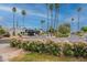 A view of the community entrance with vibrant pink flower bushes and tall palm trees at 7960 E Camelback Rd # 110, Scottsdale, AZ 85251