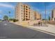 Exterior view of condo building with yellow accent parking, blue sky, and side street at 7960 E Camelback Rd # 110, Scottsdale, AZ 85251