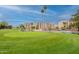 Well-manicured golf course with lush green grass, pond, and residential buildings in the background at 7960 E Camelback Rd # 110, Scottsdale, AZ 85251