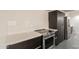 Close-up of a kitchen area with stainless steel appliances and white countertops, gray tile flooring at 7960 E Camelback Rd # 110, Scottsdale, AZ 85251