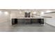 Open-concept kitchen with large island, stainless appliances, pendant lighting, and gray tile flooring at 7960 E Camelback Rd # 110, Scottsdale, AZ 85251
