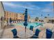 Community pool area with lounge chairs, umbrellas, tables, and accessible swimming pool at 7960 E Camelback Rd # 110, Scottsdale, AZ 85251
