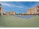 A view of tennis courts surrounded by tall residential buildings and lush landscaping at 7960 E Camelback Rd # 110, Scottsdale, AZ 85251