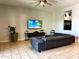 Modern living room with a large gray sectional sofa and a wall-mounted TV, illuminated by natural light at 9760 E Thatcher Ave, Mesa, AZ 85212