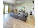 Spacious living room with tiled floors, a large sectional sofa, and a modern entertainment center at 9760 E Thatcher Ave, Mesa, AZ 85212