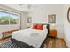Bright bedroom showcasing a plush bed, a large window offering neighborhood views, and stylish accents at 10832 N 37Th St, Phoenix, AZ 85028