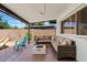 Covered patio with a large cushioned sectional, a fire pit, and desert landscaping at 10832 N 37Th St, Phoenix, AZ 85028