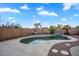 Backyard pool with desert landscaping featuring an artificial rock waterfall and tan brick wall at 1123 N Agave St, Casa Grande, AZ 85122