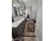 Bright bathroom features double sinks with white marble countertops, glass block wall, and a decorative rug at 11390 N 78Th St, Scottsdale, AZ 85260