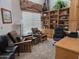 Cozy home office featuring built-in wooden shelves, comfortable chairs, and a window with blinds at 11390 N 78Th St, Scottsdale, AZ 85260