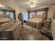 Spacious main bedroom features a large bed, neutral colors, a ceiling fan, and large windows at 11390 N 78Th St, Scottsdale, AZ 85260