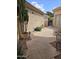 Tiled patio features desert plants, accent lighting, and a walkway leading to a decorative iron gate in backyard at 11390 N 78Th St, Scottsdale, AZ 85260