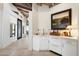 Elegant hallway features white walls, tile flooring, and a stylish wet bar with custom cabinetry at 11416 N Blackheath Rd, Scottsdale, AZ 85254