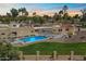 An aerial view of a luxury home featuring a sparkling pool, spa, green lawn and desert landscaping at 11416 N Blackheath Rd, Scottsdale, AZ 85254