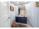 Stylish powder room boasts a floating vanity, decorative mirror, and patterned wallpaper at 11416 N Blackheath Rd, Scottsdale, AZ 85254