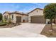 An inviting front exterior featuring a desert landscape, covered entrance, and attached two-car garage at 11609 W Andrew Ln, Peoria, AZ 85383