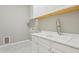 A well-lit laundry room with white cabinets, a utility sink, and modern fixtures offers functionality at 11609 W Andrew Ln, Peoria, AZ 85383