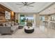 Open living room with wood accent wall, gray sectional, sliding glass doors, and eat-in kitchen at 11609 W Andrew Ln, Peoria, AZ 85383
