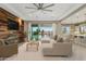 Bright living room featuring hardwood accent wall, neutral-toned furniture, and an open layout to the kitchen at 11609 W Andrew Ln, Peoria, AZ 85383
