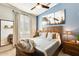 Cozy bedroom featuring a wood bed frame, mountain artwork, and a window with plantation shutters at 11988 W Nadine Way, Peoria, AZ 85383