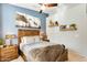 Comfortable bedroom with a wooden bed frame, mountain art, and decorative shelves with plants at 11988 W Nadine Way, Peoria, AZ 85383