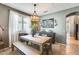 Inviting dining room with a wooden table, bench seating, and a modern light fixture at 11988 W Nadine Way, Peoria, AZ 85383