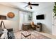 Well-lit home office with a wooden desk, rolling chair, and comfortable seating at 11988 W Nadine Way, Peoria, AZ 85383
