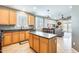 Well-lit kitchen featuring wood cabinets, an island, and a view into the living room at 11988 W Nadine Way, Peoria, AZ 85383