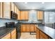 Modern kitchen with stainless steel appliances, dark countertops, and wood cabinets at 11988 W Nadine Way, Peoria, AZ 85383