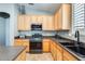 Functional kitchen with wood cabinets, dark countertops, and stainless steel appliances at 11988 W Nadine Way, Peoria, AZ 85383