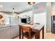 A view of the living room and kitchen, with a wood table with seating between the two rooms at 11988 W Nadine Way, Peoria, AZ 85383