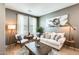Comfortable living room featuring neutral tones, plantation shutters, and stylish furniture with natural light at 11988 W Nadine Way, Peoria, AZ 85383