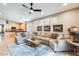 Spacious living room with a large sectional sofa and a view to the kitchen and table area beyond at 11988 W Nadine Way, Peoria, AZ 85383