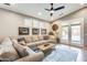 Living room with a large sectional sofa, a wooden coffee table, and a ceiling fan and modern art at 11988 W Nadine Way, Peoria, AZ 85383
