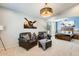 Inviting sitting area with leather chairs, opening to a Primary bedroom with a wooden bed at 11988 W Nadine Way, Peoria, AZ 85383