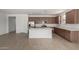 Open-concept kitchen with stainless steel appliances, white countertop island, and seamless flow to the living area at 12366 W Marguerite Ave, Avondale, AZ 85323