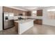 Modern kitchen with stainless steel appliances, white countertops, a large island, and wooden cabinetry at 12366 W Marguerite Ave, Avondale, AZ 85323