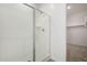 Sleek, glass enclosed walk-in shower with neutral tile and linen closet adjacent to the shower space at 12366 W Marguerite Ave, Avondale, AZ 85323