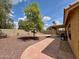 Spacious backyard featuring desert landscaping, covered patio, and mature tree at 1314 W Kingbird Dr, Chandler, AZ 85286