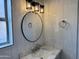 Bathroom vanity with marble countertop, a round mirror, and modern black and chrome lighting at 1314 W Kingbird Dr, Chandler, AZ 85286