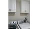 A well-lit laundry room with white cabinets above the washer and dryer at 1314 W Kingbird Dr, Chandler, AZ 85286