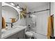 Modern bathroom with tiled shower and glass door, complemented by a stylish vanity and circular mirror at 13419 N 35Th St, Phoenix, AZ 85032